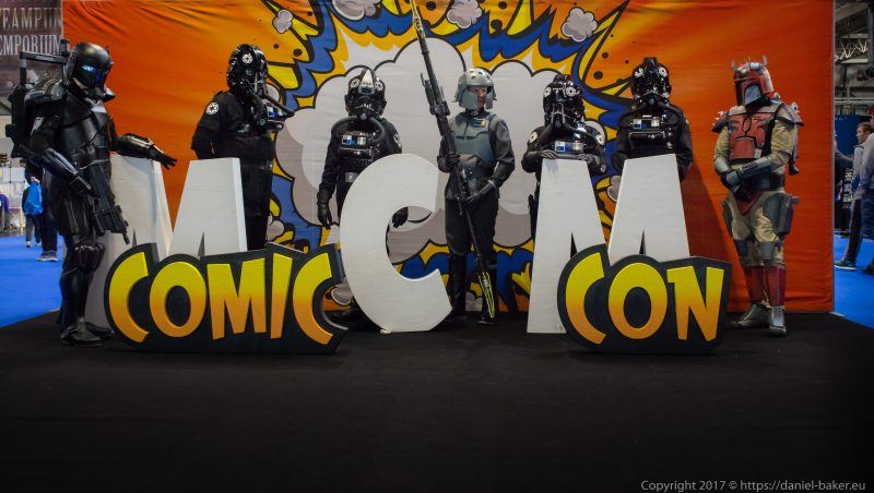 Various Star Wars characters in cosplay standing behind the MCM comiccon logo