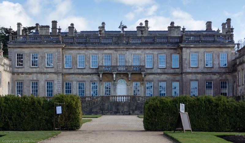 Dyrham Park House, a large manor house viewed from the garden with blue sky and a few white clouds above